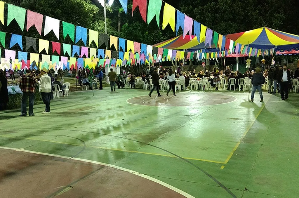 Festa junina no clube, com bandeirinhas coloridas sobre a quadra