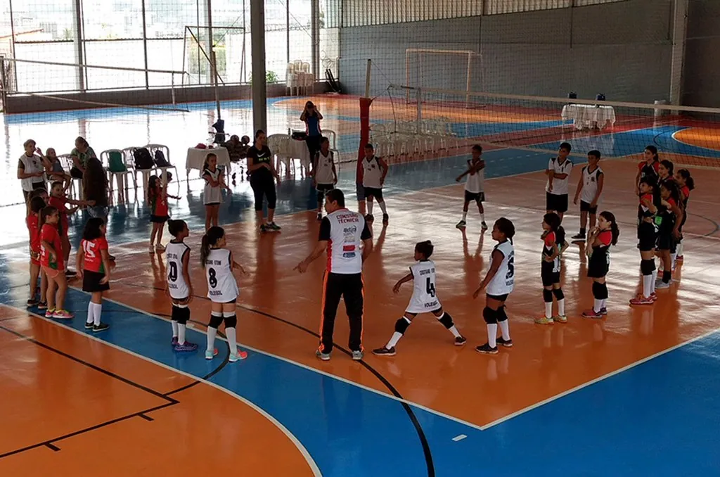 Crianças jogando vôlei no ginásio